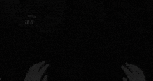 a person is playing a video game in a dark room with blood on their hands .