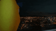 a person in a yellow shirt is looking out a window at night