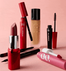 a bottle of glimmer mascara sits next to a red lipstick