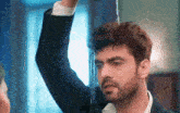 a man in a suit is standing in front of a window with water coming out of it .