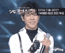 a young man singing into a microphone with the words yg treasure box behind him