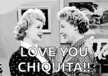 a black and white photo of two women standing next to each other and saying `` love you chiquita '' .