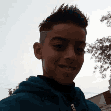 a young boy with a shaved side of his head is smiling for the camera