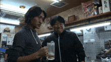 two men standing in front of a sign that says kirin on it
