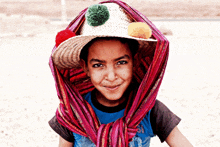 a young boy wearing a hat and a scarf around his neck