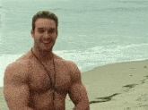 a shirtless man is standing on a beach smiling .