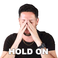 a man is covering his face with his hands and the words hold on are written above him