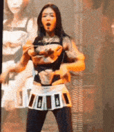 a woman is standing on a stage wearing a skirt and a purse .