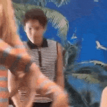 a man in a striped shirt is standing next to a woman in a black and white striped shirt .