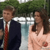 a man and a woman are standing next to each other in front of a pool