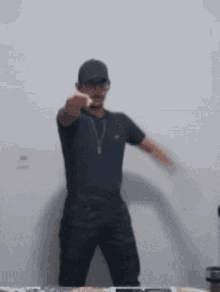 a man wearing a hat is dancing in front of a wall