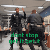two police officers giving each other a high five in an office with the words " dont stop get it get it "