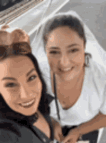 two women are posing for a picture and smiling for the camera .