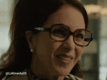a close up of a woman wearing glasses with the hashtag lialmeida05 on the bottom