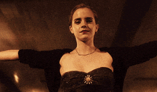 a woman with her arms outstretched wearing a black top