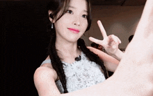 a woman in a white dress making a peace sign