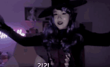 a woman in a witch costume is dancing in front of a neon sign that says halloween .
