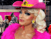 a blonde woman wearing a pink cowboy hat with a star on it