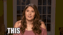 a woman in a pink shirt is making a funny face and saying this .