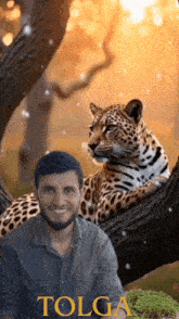 a man sitting next to a leopard with the word tolga on the bottom
