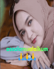 a woman wearing a hijab is laying on a table with the words assalamualaikum above her