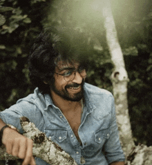a man with glasses and a beard is smiling
