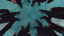 a group of men standing in a circle with netflix written on the bottom of the screen