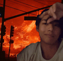 a man is taking a selfie in front of a fire