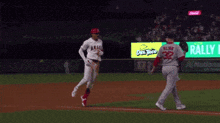 a baseball player with the number 32 on his back is running towards another player