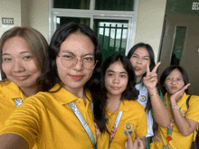 a group of girls are posing for a picture in front of a sign that says exit