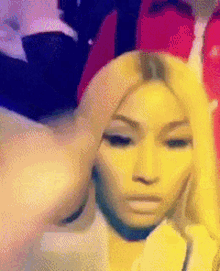 a woman with blonde hair is making a funny face while taking a selfie .