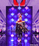 a drag queen is walking down a runway with purple lights behind her and the words t4yce tumblr below her