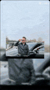 a man wearing sunglasses is standing in front of a car with a caption that says " capcut "