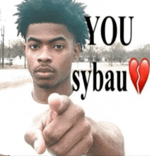 a man is pointing at the camera with the words " you sybau " written above him