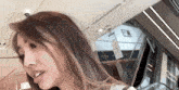 a woman with long hair is standing in front of an escalator in a shopping mall .