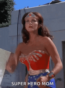 a woman in a wonder woman costume is standing in front of a building .