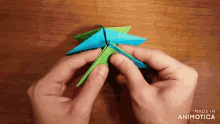 a person is making an origami star with the words made in animatica visible