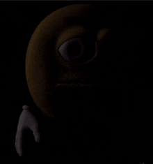 a close up of a smiley face in the dark with a hand .