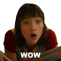 a woman with a surprised look on her face is holding a magazine that says wow on it