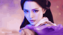 a close up of a woman 's face with a purple background and the word meteor on the bottom
