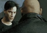 two men are standing next to each other and looking at each other in a room .
