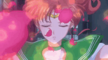 a close up of a girl in a green sailor suit with a pink flower on her face .