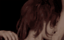 a woman with red hair is smiling with her arms up