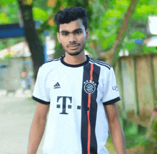 a young man wearing a white adidas t-mobile jersey