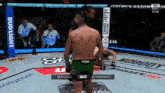 a man in a green venum shorts is fighting another man in a boxing ring