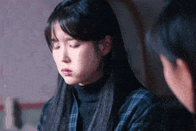 a woman in a plaid shirt is looking down