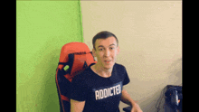 a man wearing a black shirt that says addicted
