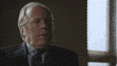 a man in a suit and tie is saying what now