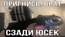 a man in a helmet is holding a gun with russian writing