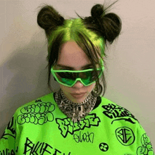 billie eilish is wearing neon green sunglasses and a neon green shirt with graffiti on it